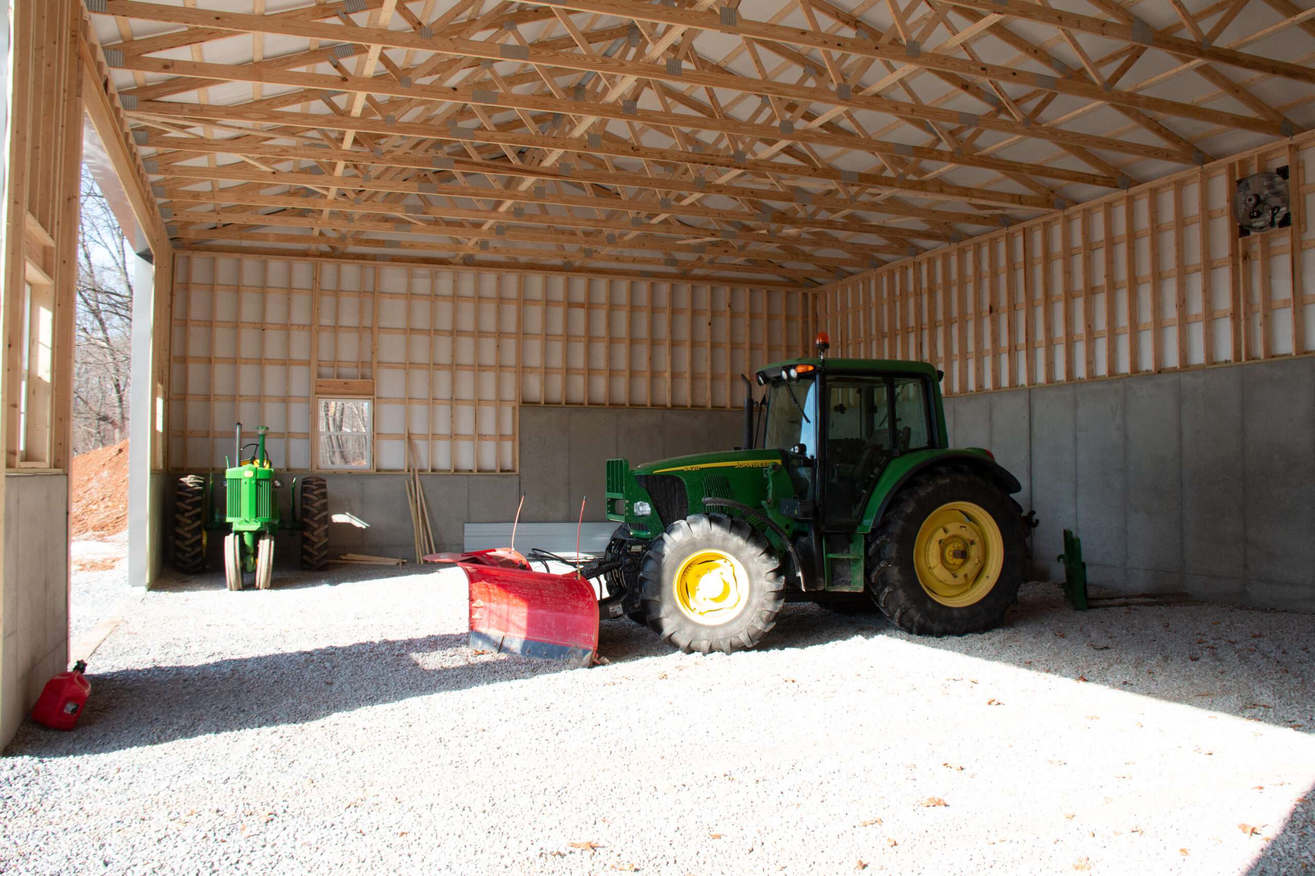Tractor sitting inside a large shed. Use our building planner page today.
